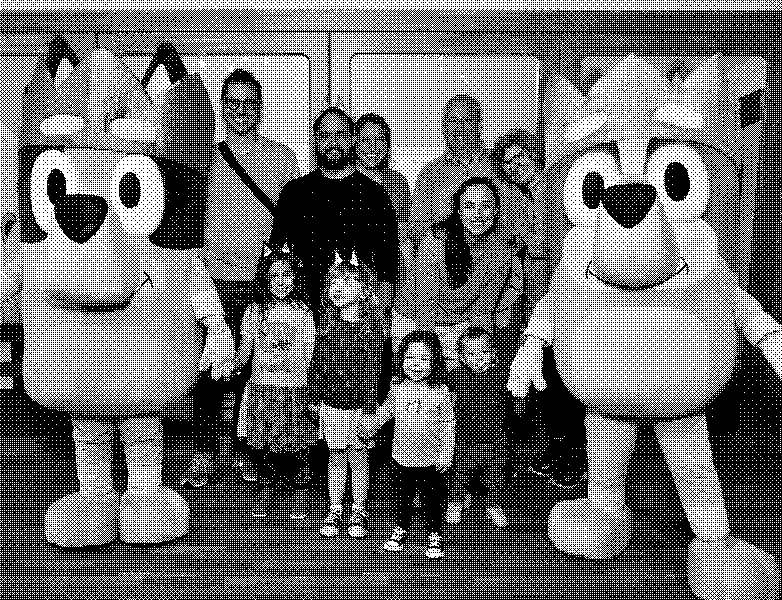 Family photo op with Bluey and Bingo: three generations smiling while the kids in Bluey ears line up between the giant mascots.