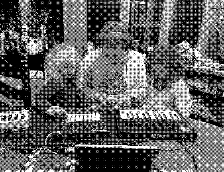 Dad and two kids huddled around a tabletop music setup, each exploring synth pads and keys in a cozy kitchen studio scene.
