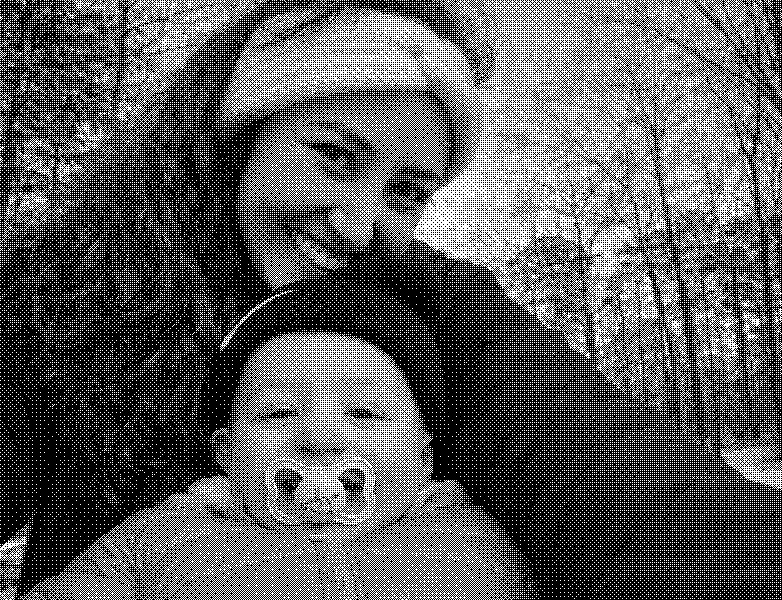 Snowy woods selfie: bundled mom and baby, rosy cheeks, winter headbands, big smiles.