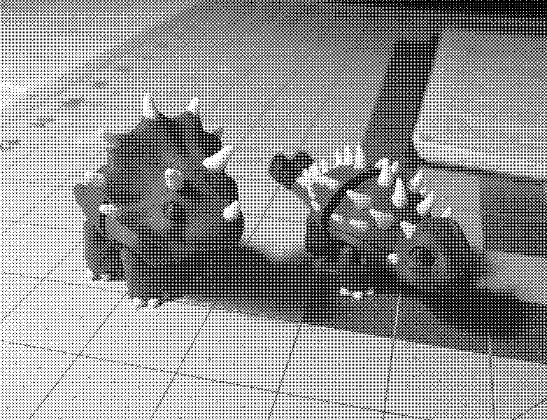 Two tiny pink, horned dinos stand on a cutting mat, lit warmly like fresh desk-bound creations.